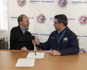 It’s official: Anthony Chiarello, president and CEO of TOTE, and Kevin Graney, vice president and general manager at General Dynamics NASSCO, shake hands following delivery signing ceremony aboard the Perla Del Caribe at the NASSCO shipyard.