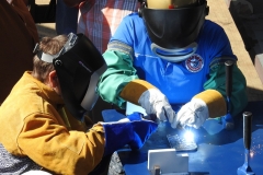 Ms. Travie Ross welds her initials onto the keel.