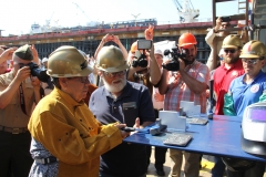 Ms. Travie Ross helps prepare the keel. She and her sister, Ms. Tracie Ross, served as the ceremony’s honorees.
